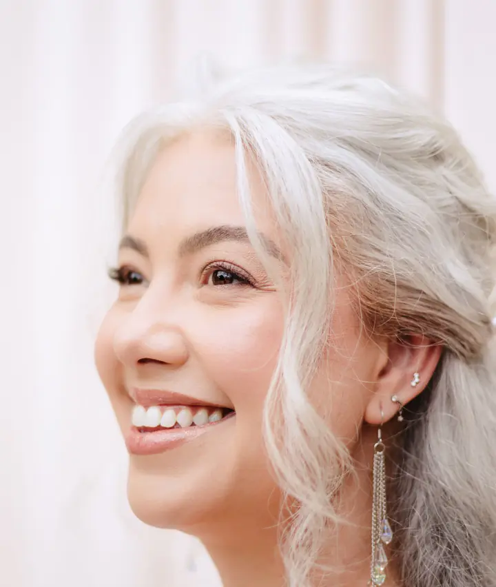 Smiling woman with silver hair and earrings